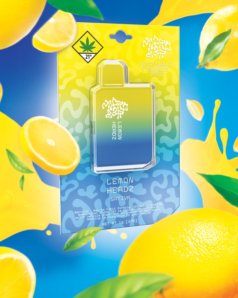 A Lemon Headz Micro Bar, surrounded by lemons and a splash of juice on a royal blue background.
