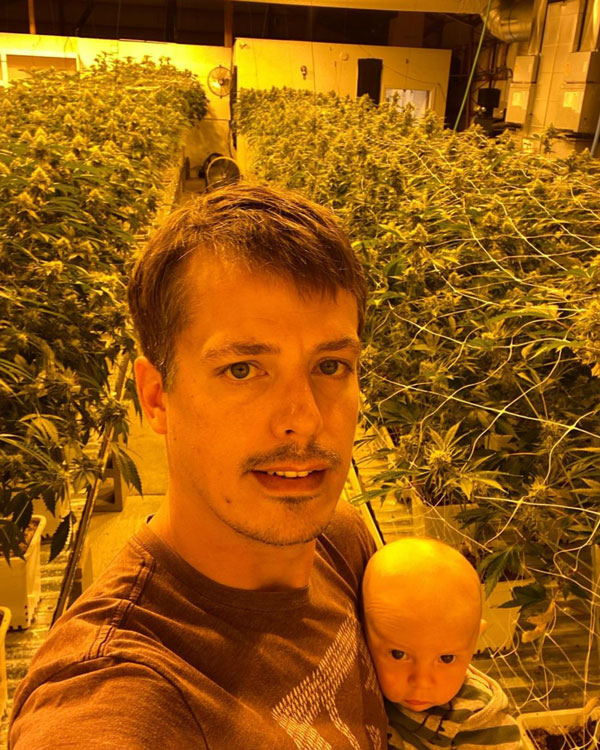 A selfie of Andrew Cole and his young son in the Kindness Cannabis grow room.
