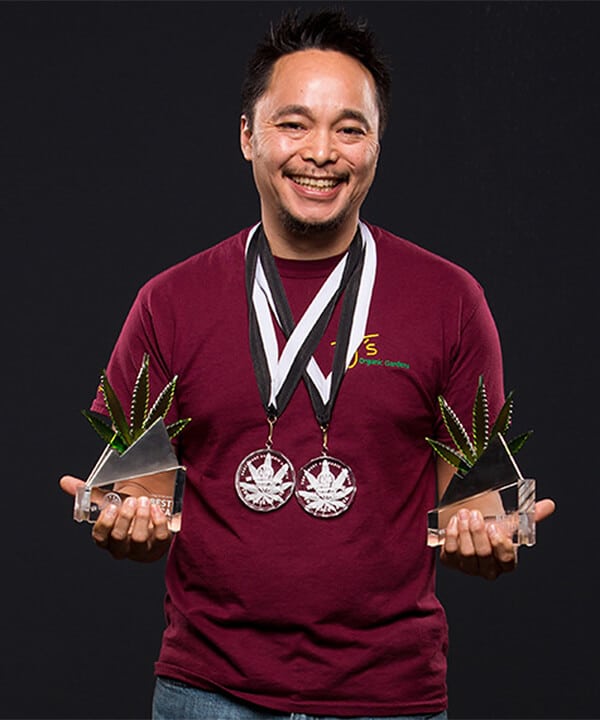 James Orpeza holding cannabis awards for Tj's Organics flower